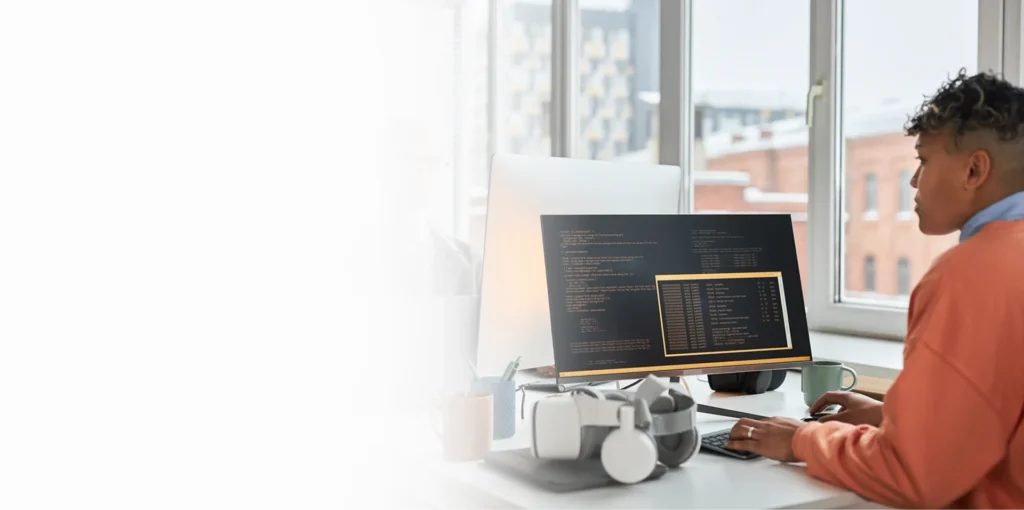 IT specialist working at a monitor showing code by an office window, cybersecurity services Lafayette