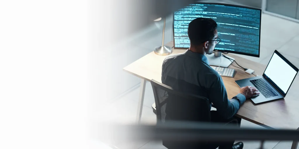 Security engineer reviewing code on multiple monitors, cybersecurity services in Minneapolis