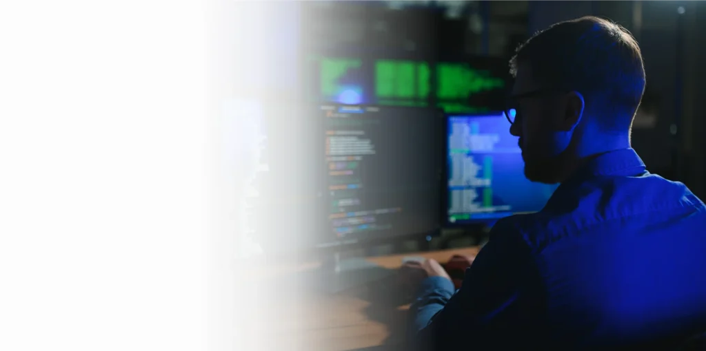 Security analyst working at monitors in a dark operations room, cybersecurity services Cincinnati