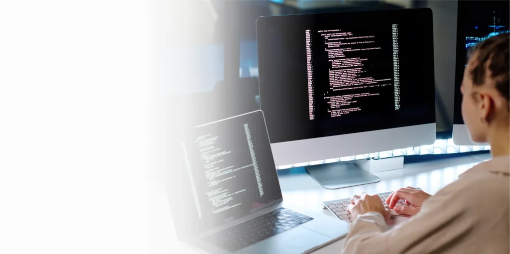 IT specialist reviewing code on a monitor, cybersecurity services in Charlotte