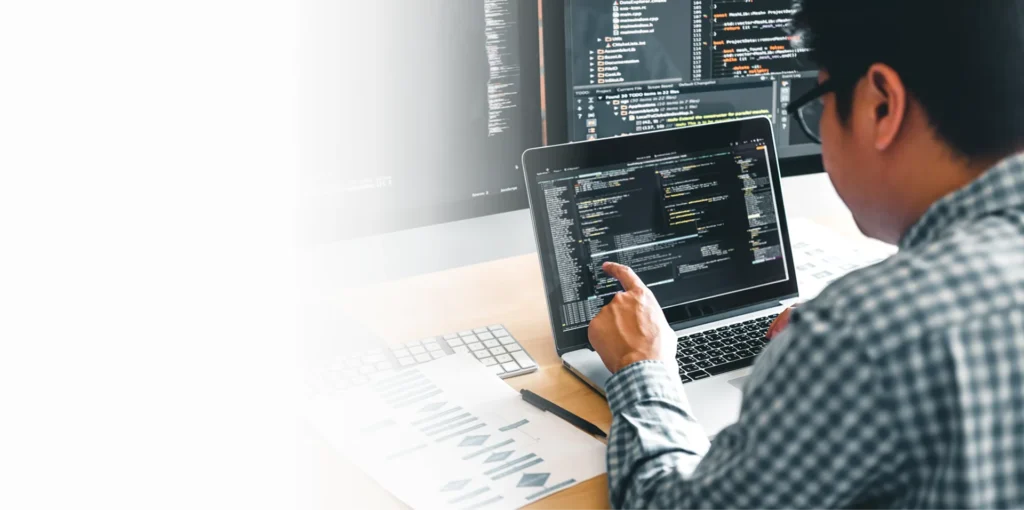 IT specialist reviewing code on a laptop, cybersecurity services in Dallas