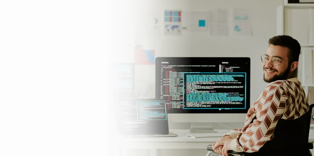 Smiling IT specialist at a monitor showing code, cybersecurity services in Phoenix