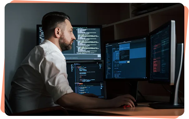 Security analyst monitoring code on multiple screens, cybersecurity services Dallas