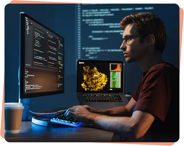 Developer analyzing code on monitors at night, cybersecurity services Minneapolis