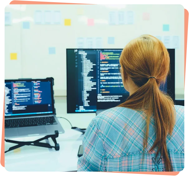 Developer reviewing code on multiple monitors, cybersecurity services in Honolulu