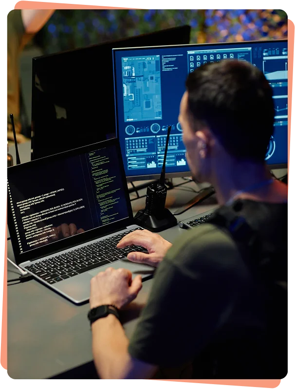Security analyst monitoring dashboards and code on multiple screens, cybersecurity services Atlanta