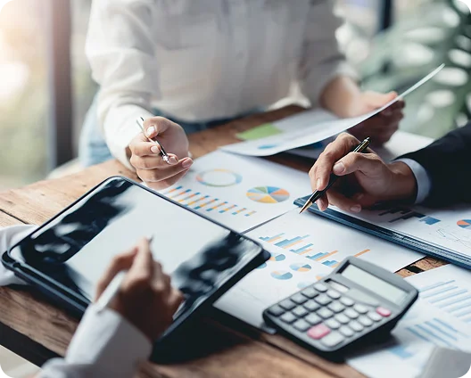 Accountants reviewing financial charts with a tablet and calculator, cybersecurity for finance firms