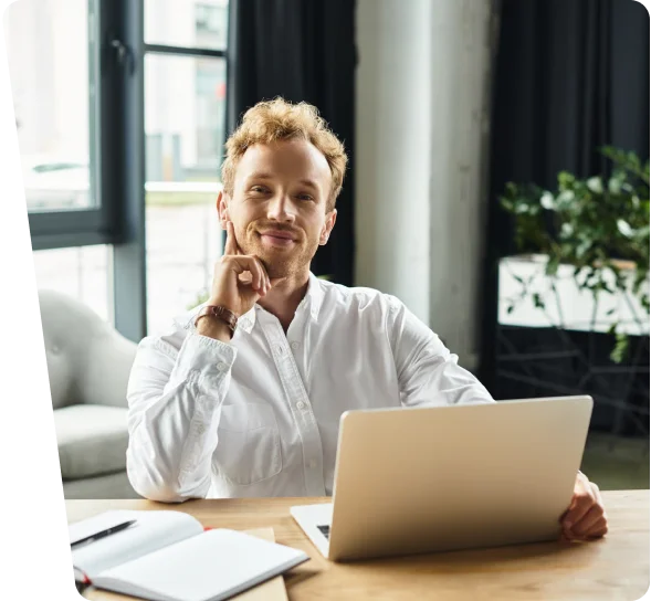 Smiling business owner working on a laptop at a desk, cybersecurity services Los Angeles