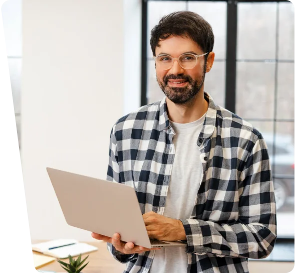 Smiling IT consultant in a plaid shirt holding a laptop, cybersecurity services in Charlotte