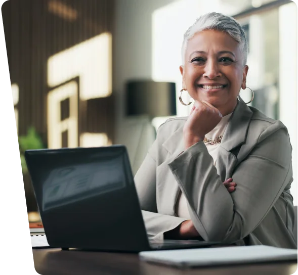 Smiling senior businesswoman at a laptop in an office, cybersecurity services Charlotte