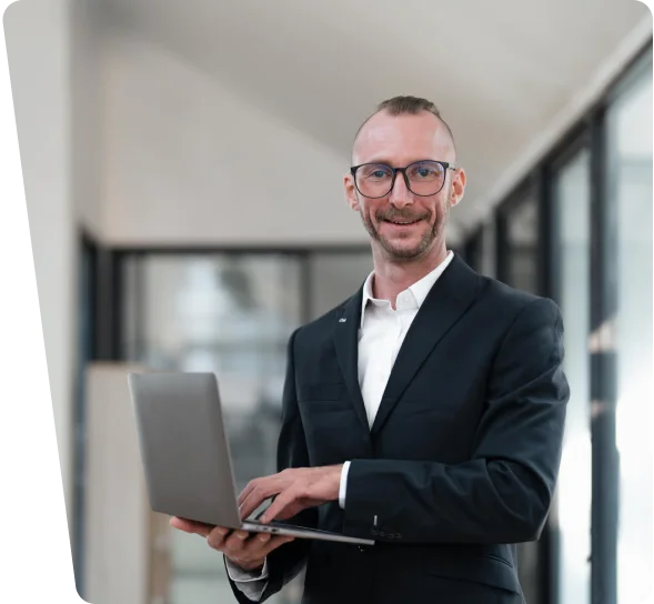 Smiling cybersecurity consultant in a suit holding a laptop, cybersecurity services Minneapolis