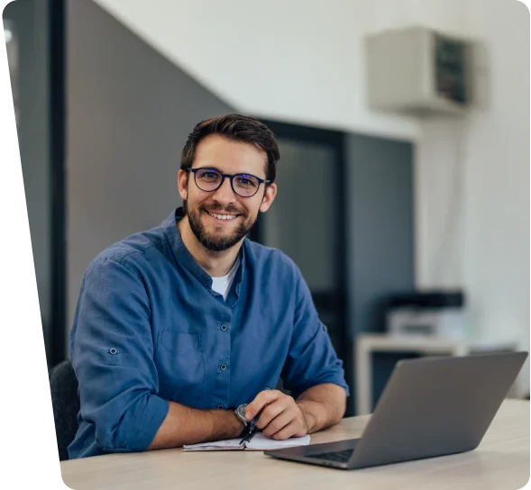 Smiling business owner with glasses at a laptop, cybersecurity services in Honolulu