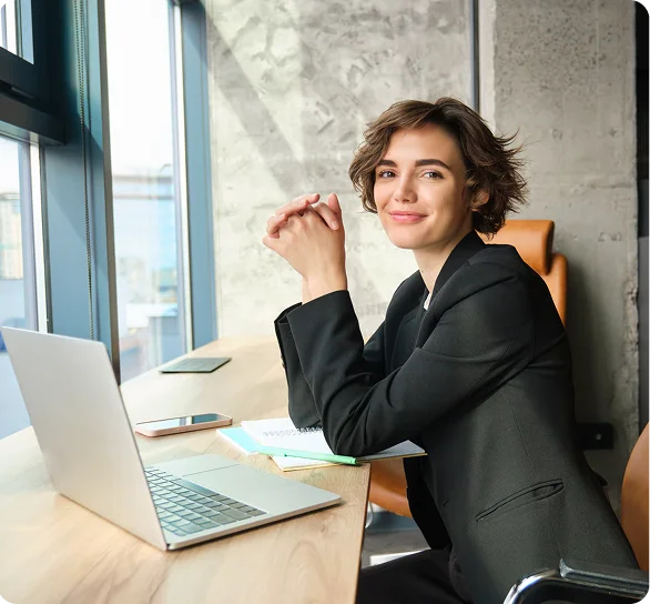 Confident businesswoman seated at a laptop in an office, cybersecurity services Austin