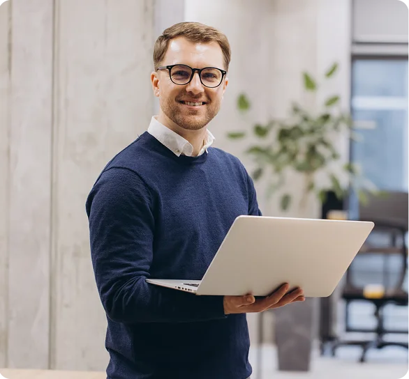 Smiling IT consultant with glasses holding a laptop, cybersecurity services in Lafayette
