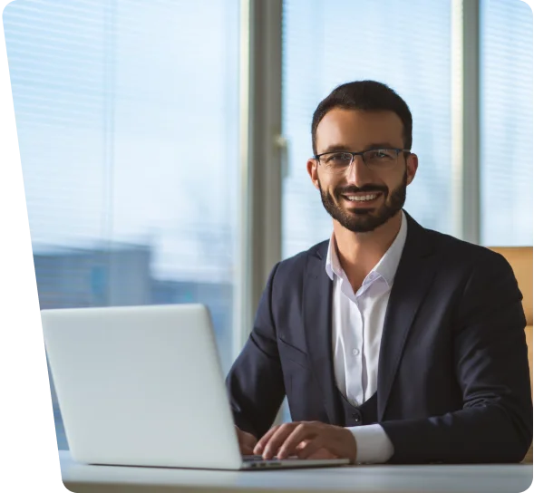 Smiling businessman with glasses working on a laptop, cybersecurity services in Phoenix