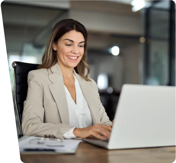 Smiling businesswoman working on a laptop at a desk, cybersecurity services Tampa